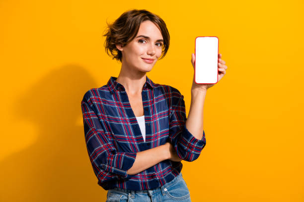 istock Photo of intelligent woman dressed checkered shirt presenting smartphone display web panel empty space isolated on yellow color background 2196368165