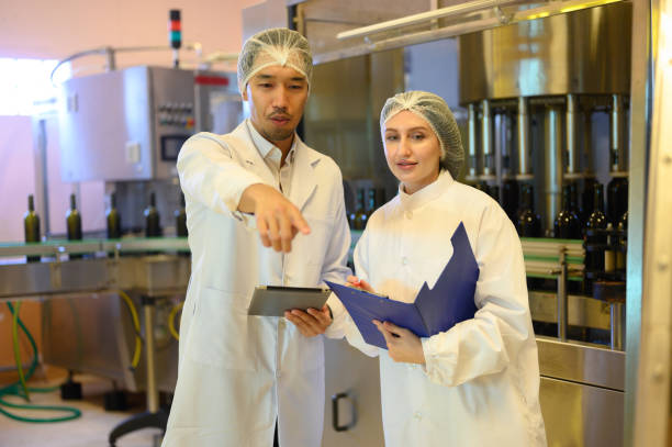 istock Wine production engineers work in the beverage industry in large modern wineries and test wines in winery warehouses. 2196368214