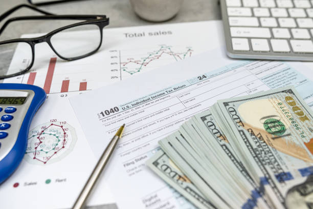 istock US 1040 form or US Individual income pen calculator dollar on desk. Accounting documents taxation 2196370071
