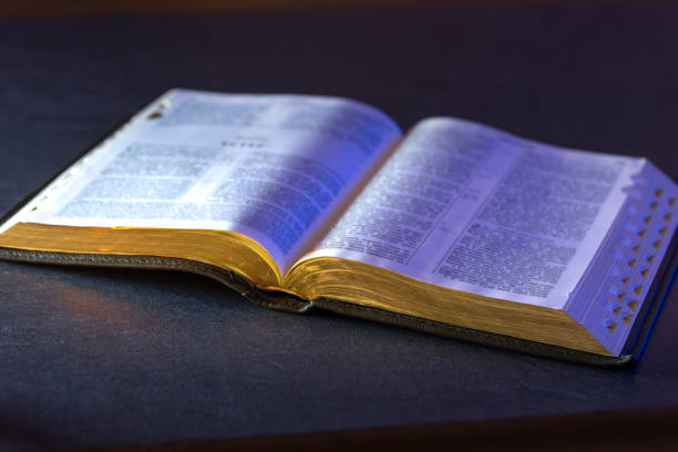 istock Open Holy Bible on the table. Religion concept. Bible on black background. 2196371424