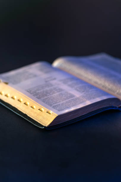 istock Open Holy Bible on the table. Religion concept. Bible on black background. 2196371430