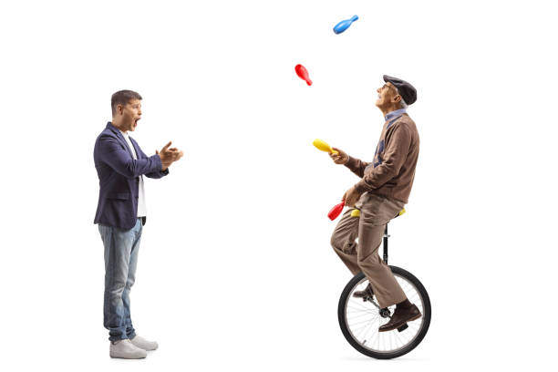istock Amazed man clapping and watching an elderly man juggling on a mono cycle 2196372410
