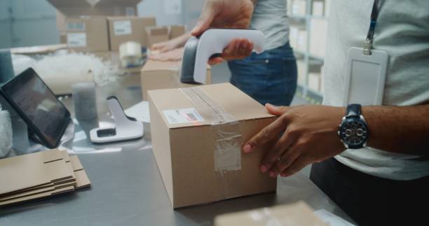 istock Close Up of Diverse Postal Workers Packing and Preparing Packages for Delivery 2196373738