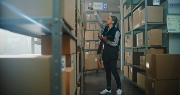 istock Female Sorting Center Employee Scans Parcels, Takes Package for Delivery to Client 2196380451