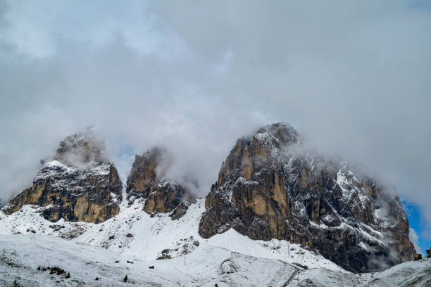 The impressive Langkofel or Sassolungo mountain in the Italian Dolomites covered in snow during a springtime morning in the Italian Alps.