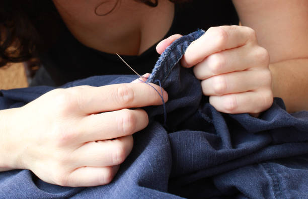 istock Repairing garments at home with skilled female hands. 2196385708