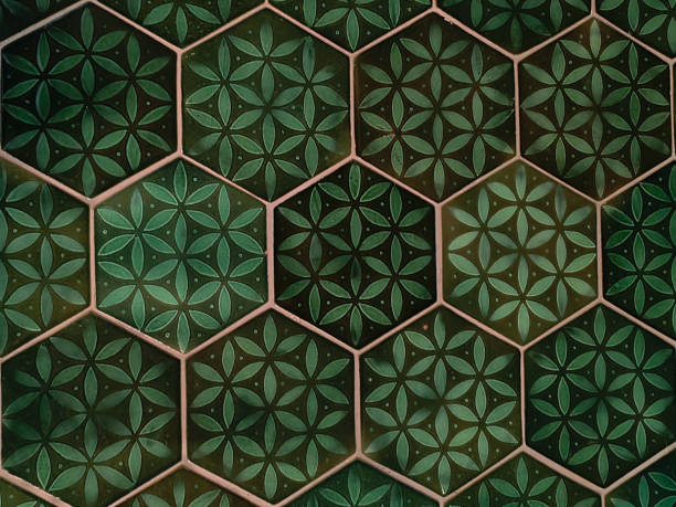 Close-up shot of green hexagon tiled floor with a floral batik design pattern. concept: Decor textile, wrapping paper, wallpaper, cultural design, home decor inspiration, unique tile pattern, geometric aesthetics, vibrant floor design, timeless craftsmanship, heritage-inspired flooring.