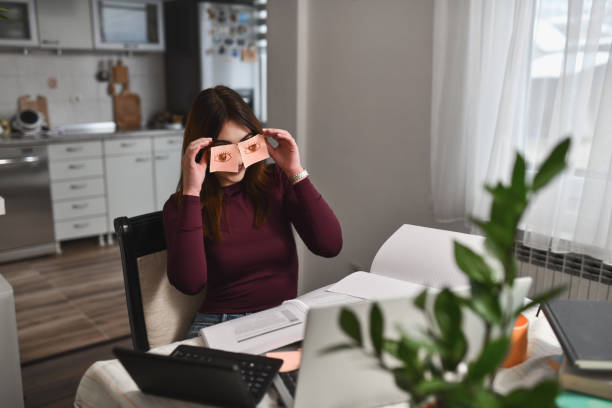 istock Female Positioning Sticky Notes With Drawings on Eyes While Being Bored in Online Class 2196387723