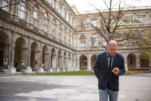 Mature University Professor Using Phone in University Yard