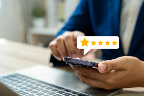 istock Close-up man using a smartphone to provide a five-star service rating, Customer satisfaction survey and feedback, Online reviews, Service quality evaluation, Customer service experience. 2196388970