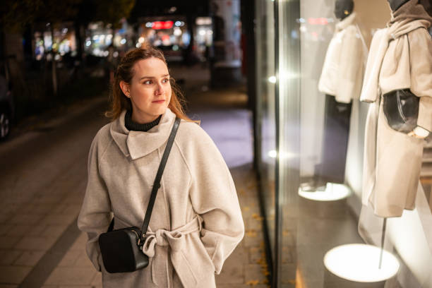 istock Cozy-Coated Woman Walking Past a Shop Window 2196390722