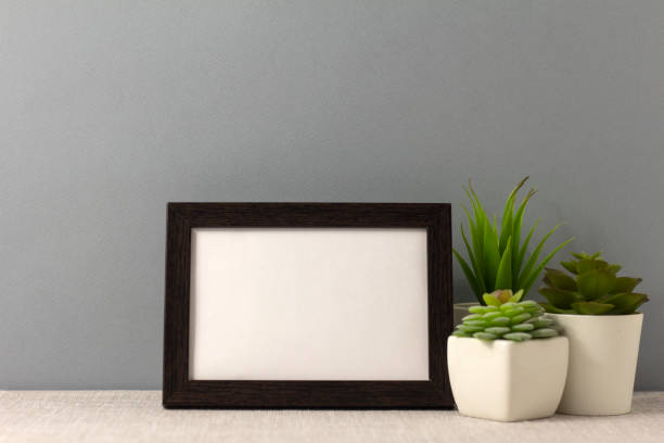 istock An empty photo frame on the table. Mini pots with succulents. A minimalist-style workspace. A place to copy. 2196392227