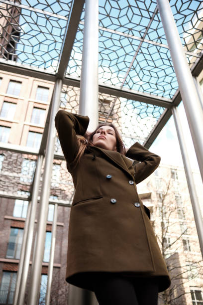 istock Stylish woman posing under metal grid structure 2196392446