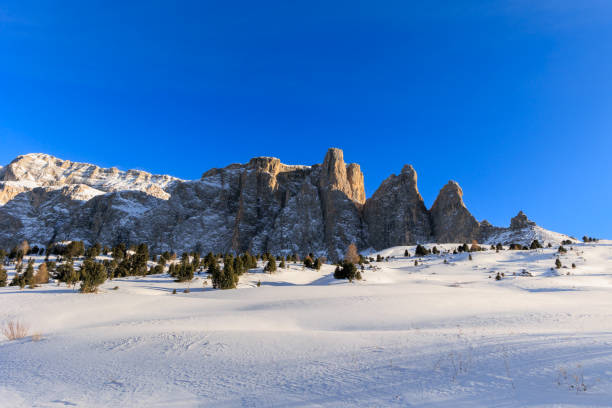The impressive Langkofel or Sassolungo mountain in the Italian Dolomites covered in snow during a springtime morning in the Italian Alps.