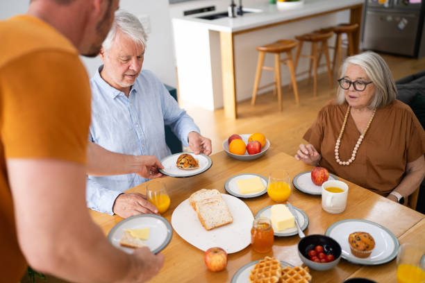istock Family Sharing Breakfast Together in Bright Kitchen Setting 2196393284