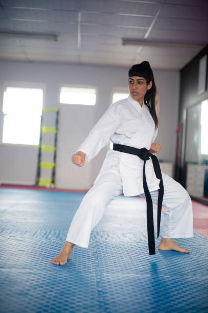 istock Ready, woman or karate in dojo for exercise, kung fu practice or self defense in class for balance. Taekwondo, fighting sports or female student in stance for learning martial arts or combat training 2196393323