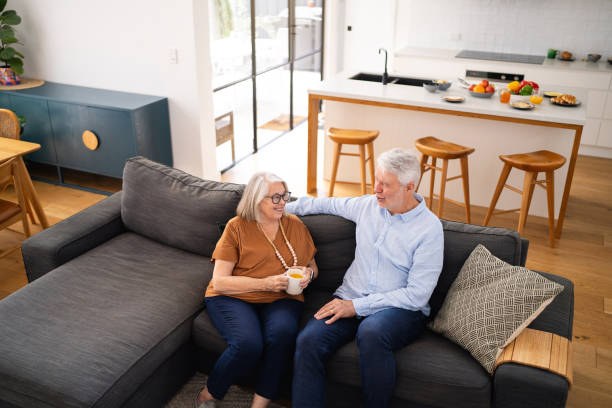 istock Smiling Senior Couple Relaxing on Sofa in Modern Open-Plan Living Room 2196395272