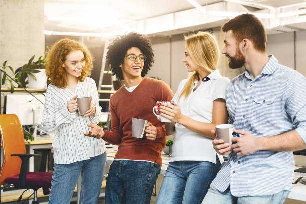 istock Cheerful colleagues enjoying coffee break in office 2196397340
