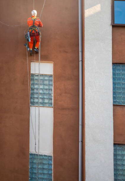istock Industrial climber hanging on ropes near modern building facade during maintenance work 2196398179