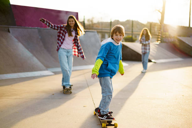 istock Children skateboarding at skateboard park 2196399946
