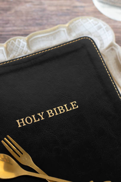 istock Holy bible book on rustic plate with golden fork and spoon 2196400093