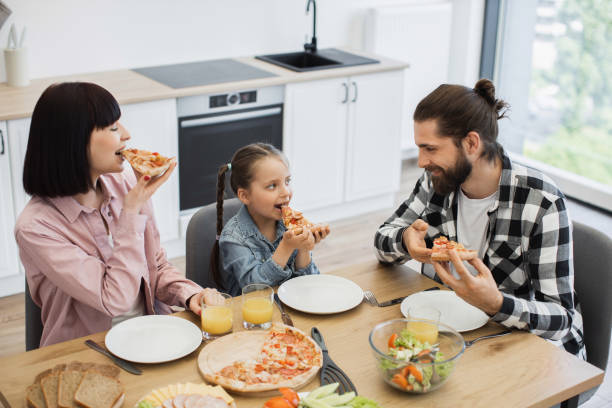 istock Caucasian family enjoying pizza breakfast together at home kitchen table 2196401992