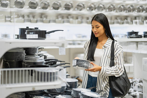 Young woman shopping for kitchen cookware in store