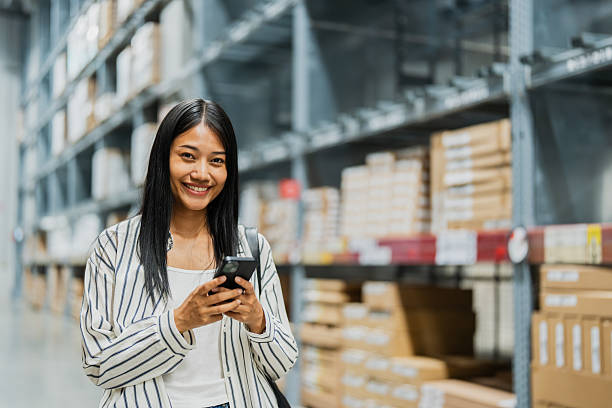 istock Happy woman using smartphone in warehouse store 2196402978