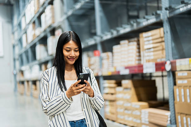 istock Happy woman using smartphone in warehouse store 2196402983