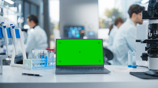 Laptop Computer With Green Screen Mock Up Display Standing On A Table ...