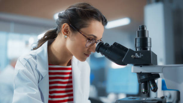 istock Genetic Research and Development Laboratory: Portrait of a Young Female Science Student Looking at a Genetic Sample Under a Microscope. Advanced Biotechnology Lab with Modern Equipment 2196407422