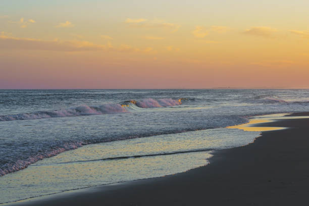 istock Soft evening light reflects on the ocean waves as they meet the beach. 2196409194