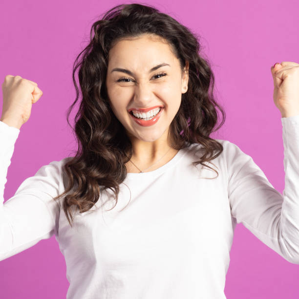 istock Excited woman with raised hands on purple background 2196411867