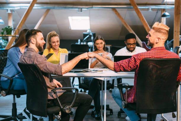 Team Members Engaging in a Handshake During a Collaborative Meeting in a Modern Office Space