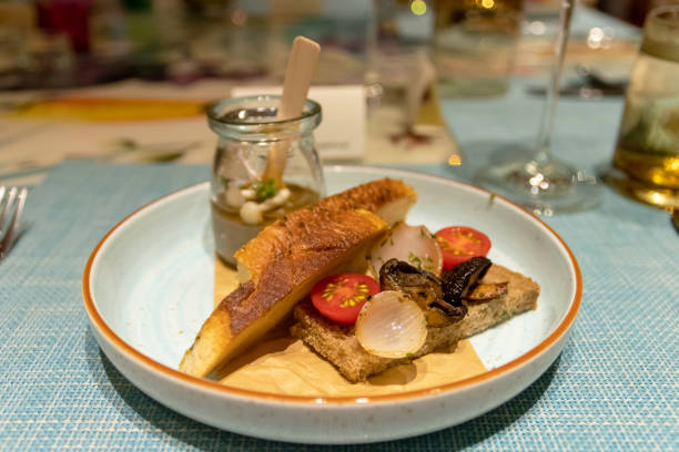 istock A beautifully plated gourmet dish featuring grilled fish, vibrant vegetables. 2196417391