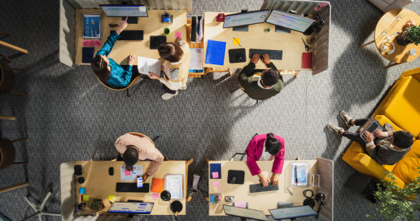 istock Top Down View of Diverse Team in a Corporate Office: Colleagues Using Desktop Computers To Analyze Financial Data, Write Reports, Calculating Sales Growth And Revenue. Technological Startup Concept 2196418343