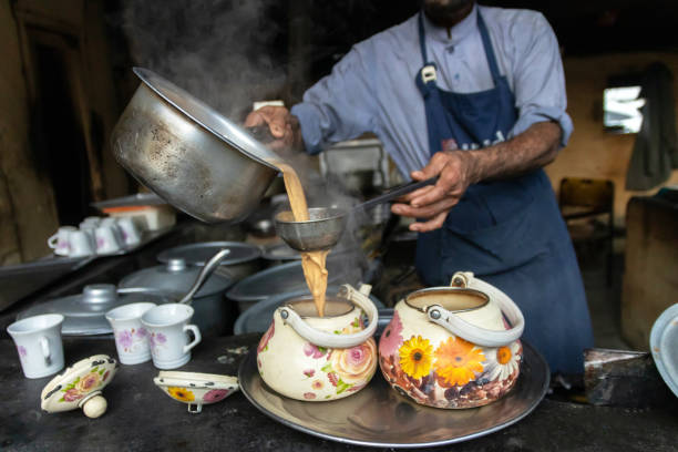 Authentic Pakistani Chai recipe can be prepared quickly and easily over the stovetop. Brewing aromatic tea in colorful pots.