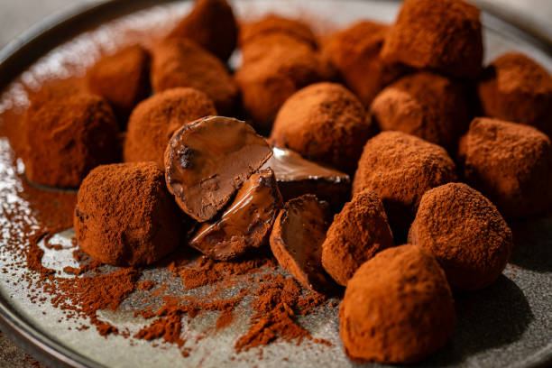 istock Tasty chocolate truffles powdered with cocoa on table. 2196421621