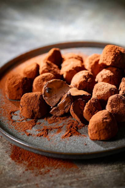 istock Tasty chocolate truffles powdered with cocoa on table. 2196421632