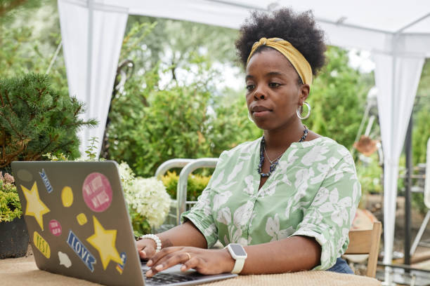 istock Black Female Landscape Designer Using Laptop Working Online in Garden 2196422236