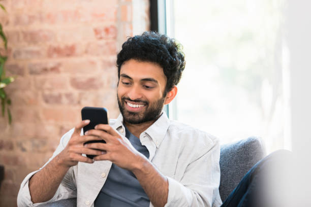 istock Smiling Man Using Smart Phone Indoors, Casual Lifestyle 2196422523
