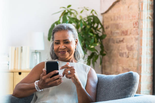 istock Smiling Senior Woman Using Smart Phone Indoors 2196422527