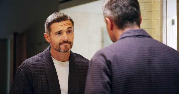 istock Mirror, reflection and thinking with mature man in bathroom for morning routine, grooming and skincare. Wake up, vision and wellness with person at home for facial, health and cleaning with self care 2196424371