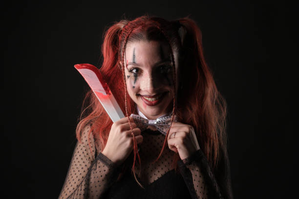 istock Playful person with fake knife in a dark setting 2196424463