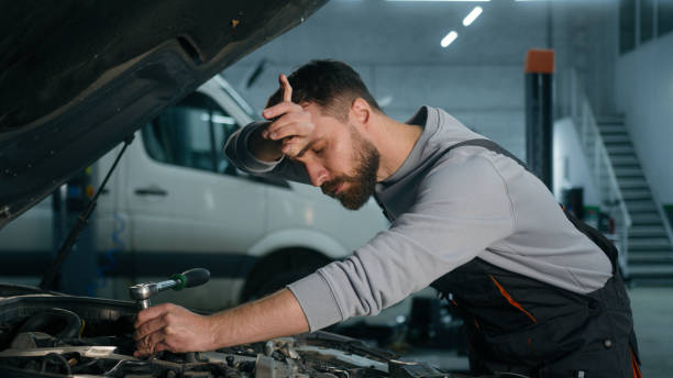 istock Caucasian mechanic in uniform repairing engine fixing motor inside open bonnet automobile professional auto service male vehicle engineer repairman man using wrench tool car maintenance in workshop 2196429204
