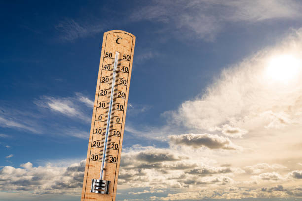 Wooden thermometer on sky background