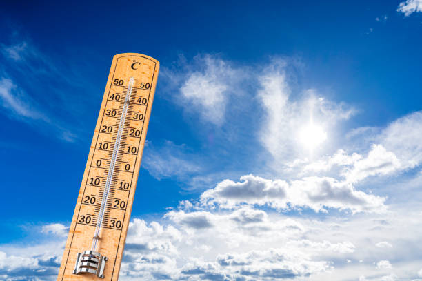 Wooden thermometer on blue sky background