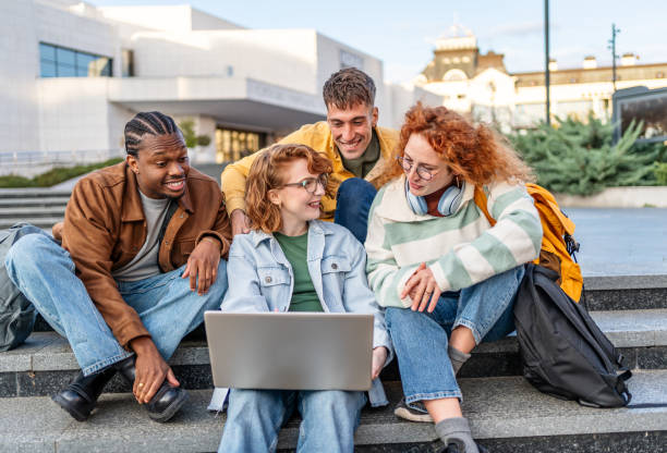 istock Group of students gathers around a laptop 2196430916