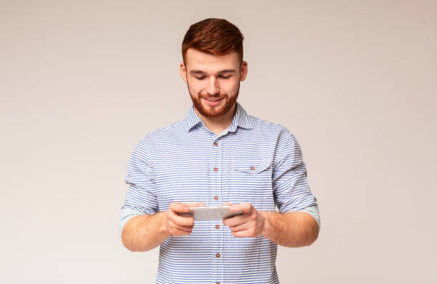 istock Young guy playing games on his phone and having fun 2196431578