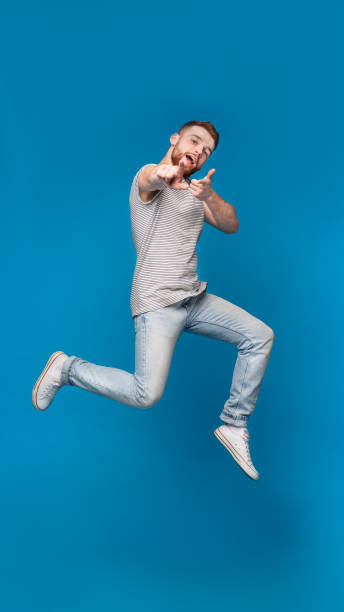 istock Cheerful man in jumping indicating happily at you 2196431627